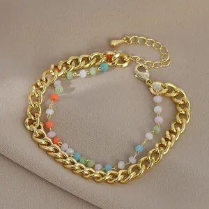 Primo piano del bracciale a doppia catena dorata con perline opache colorate e chiusura