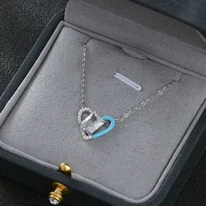 Détail macro du pendentif cœur asymétrique avec émail bleu et pierre de zircone