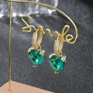 Elegante hartvormige groene smaragd oorbellen met witte zirkonia en gouden afwerking