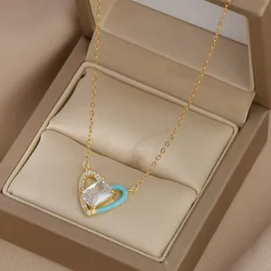Détail d'un collier pendentif cœur doré avec émail bleu et zircons dans un écrin à bijoux