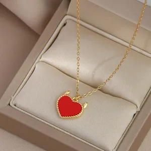 Detail of gold heart necklace with devil horns on luxury champagne satin jewelry box