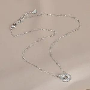 Dettaglio della collana a doppi cerchi intrecciati con zirconi lucidi su sfondo satin