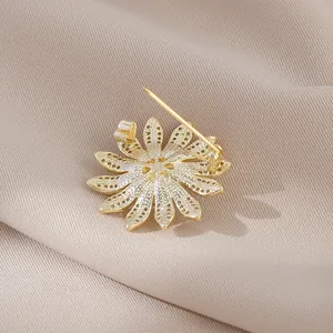 Daisy flower brooch with gold plating and honeycomb cutout detail on fabric background