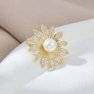 Elegant gold daisy brooch with sparkling micro-pave crystals and a large white pearl center