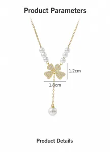 Detail of gold bow necklace with dangling pearl tassels and zircon butterfly pendant