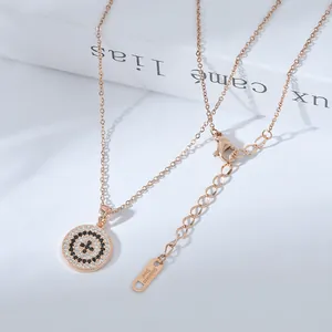 Dettaglio della collana in oro rosa con pendente in zircone e targhetta in acciaio inox
