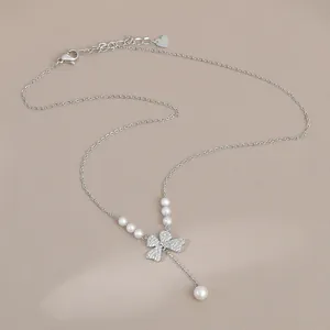 Detail of S925 silver necklace featuring a bow pendant with pearls and a lobster clasp