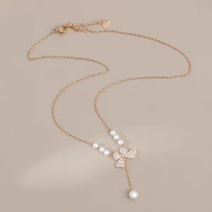 Detail of rose gold butterfly pendant with sparkling rhinestones and elegant pearls