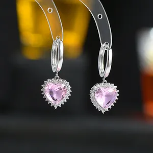 Macro dei dettagli degli orecchini a cuore rosa con cerchio in argento e pavé di zirconi