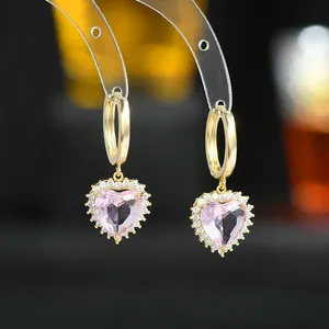 Macro di orecchini a cerchio dorati con pietre a cuore rosa e dettagli in zirconi lucidi