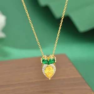Detail of gold plated carrot necklace with zircon stones on a dark wood display