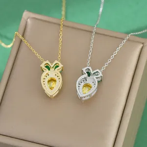 Dainty gold and silver carrot necklaces with cubic zirconia pendants on jewelry box