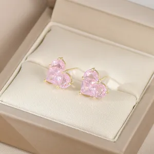 Vue macro de boucles d'oreilles cœur en zircon rose avec sertissage à griffes en or 18K