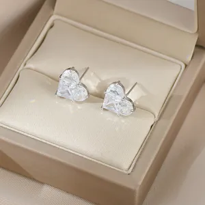 Gros plan de boucles d'oreilles cœur en émeraude verte dans un écrin de luxe
