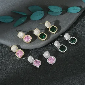 Dettaglio di orecchini quadrati con smeraldo e cristallo rosa, montature in oro e argento