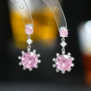 Vue macro détaillée de boucles d'oreilles pendantes en zircon rose avec aiguille en argent S925