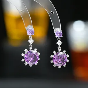 Vue détaillée des boucles d'oreilles flocon en argent avec cristaux violets sur support