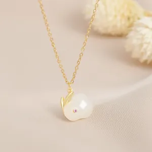 Detail of a rabbit pendant with white faux jade and golden ears on a delicate chain