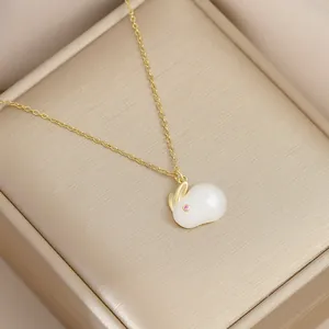 Detailed view of a gold-plated rabbit pendant with faux jade inlay on champagne silk