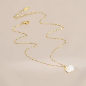 Close-up of gold-plated rabbit necklace with white resin pendant and pink eye detail