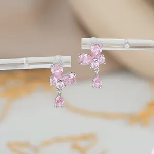 Macro shot of silver butterfly earrings with pink pear-cut crystals on acrylic stands