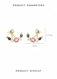 Vue détaillée de boucles d'oreilles dorées avec zircons colorés de 2 cm de large et 1,7 cm