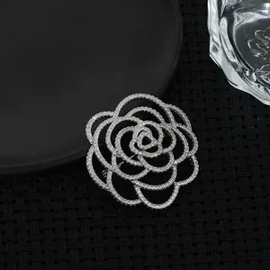 Elegant silver camellia flower brooch with layered petals and white crystal accents