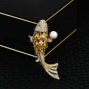 Macro shot of koi fish brooch featuring yellow gems, micro-paved zircons and white pearl