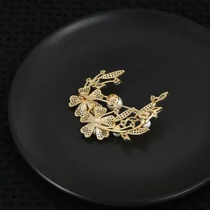Vergoldete Schalenblüten-Brosche mit Perlen und Zirkonia auf schwarzem Tablett