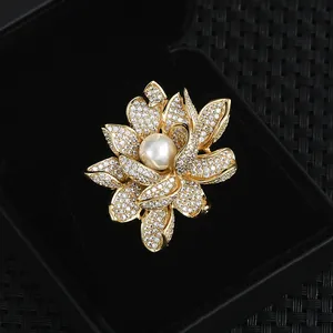 Broche lotus luxueuse en zircons avec perle blanche dans un écrin à bijoux noir chic