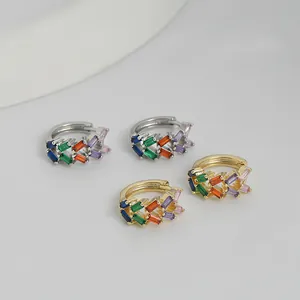 Dettaglio macro di orecchini a cerchio in oro e argento con zirconi multicolore