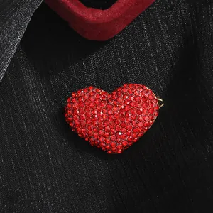Elegant red heart brooch with crystal rhinestones on a textured black background