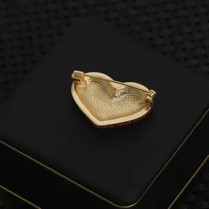 Macro view of the gold-plated back with secure pin clasp on a red crystal heart brooch