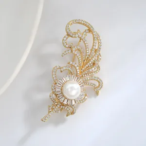 Broche luxueuse en forme de plume avec perle et diamants pavés sur monture dorée