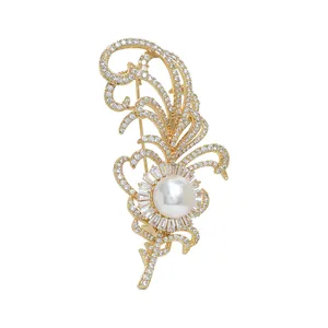 Élégante broche plume dorée avec perle centrale et pavé de cristaux de zircone