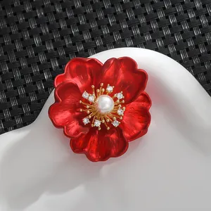 Détail de la broche pivoine rouge avec pétales brossés et perle blanche centrale