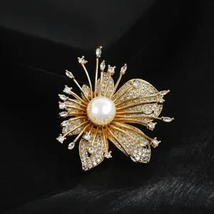 Detailed macro view of the gold flower brooch with pavé zircon petals and a large pearl center
