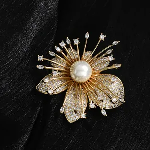 Elegant floral brooch with center pearl and zircon petals on a black silk background