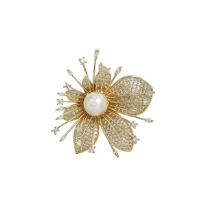 Elegant gold flower brooch featuring a large white pearl and zircon pave-set petals