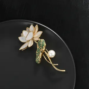 Élégante broche lotus dorée avec pétales en perle blanche et pierres vertes