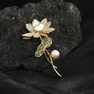 Broche lotus élégante avec pétales en nacre blanche, feuille verte et perle sur soie
