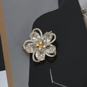 Macro shot of gold-plated flower brooch featuring large oval zircons and micro-pave crystals
