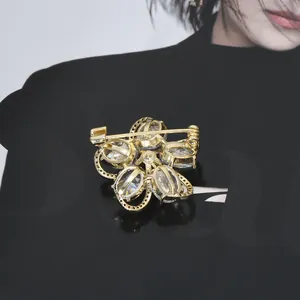 Back view of gold plated flower brooch with micro-paved zircons and secure pin clasp