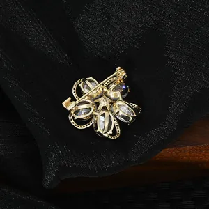 Detail view of the golden alloy back structure and secure safety pin on the flower brooch
