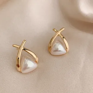 Elegante gouden pareloorknopjes met een geometrisch gekruist ontwerp voor vrouwen