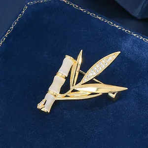 Broche bambou dorée avec pierres d'opale et feuilles de zircon sur boîte en velours