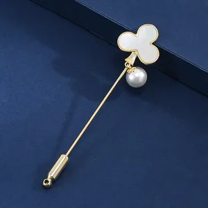 Elegant clover stick pin with natural shell inlay and white pearl on a blue background