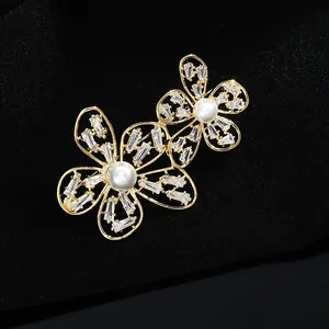 Détail de broche double fleur avec perles blanches et zircons cubiques scintillants