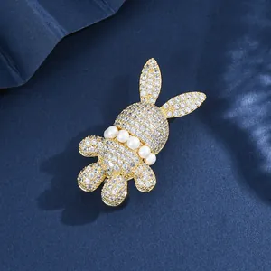 Elegante spilla a coniglio con zirconi incastonati e dettagli in perle su fondo blu