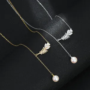 Détail de colliers en Y dorés et argentés avec pendentifs feuilles et perles en goutte